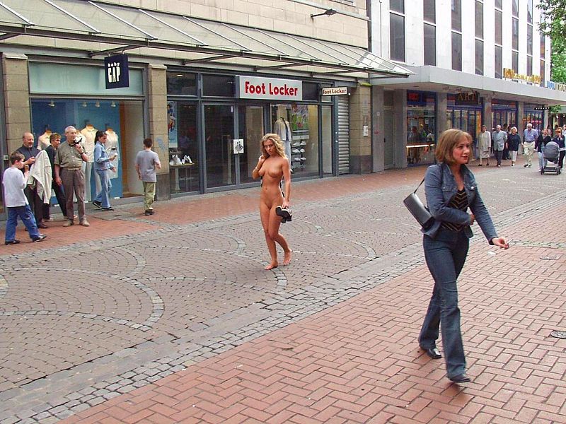 Crazy blonde slut walks through town wearing nothing at all