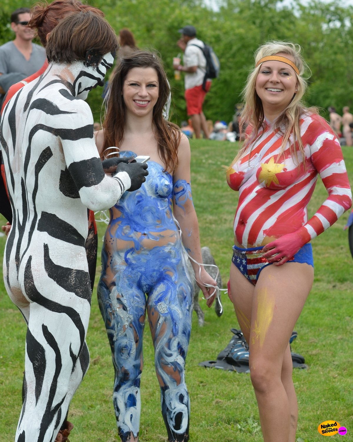 Cute girl goes to a festival wearing only bodypaint