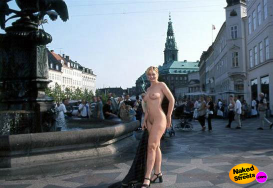 Big boobed blonde poses naked on the square