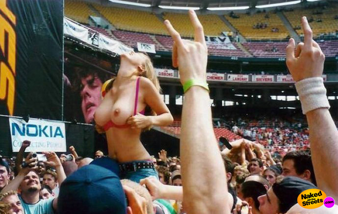 Sexy blonde girl flashes her tits at a concert