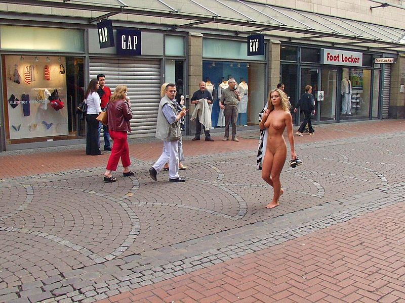 Crazy blonde slut walks through town wearing nothing at all