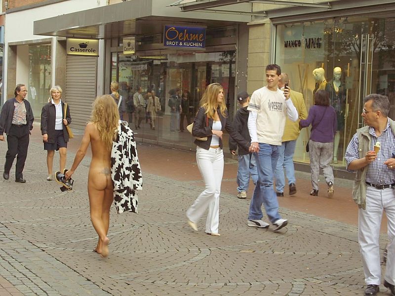 Crazy blonde slut walks through town wearing nothing at all